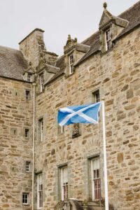 Scottish flag flying in front of a rustic building