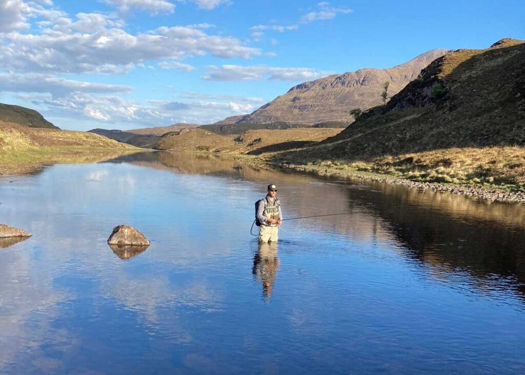 James Curley stood in a lake fishing. 