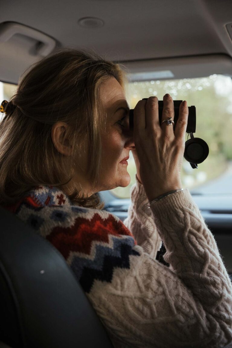 Woman with binoculars inside a Land Rover