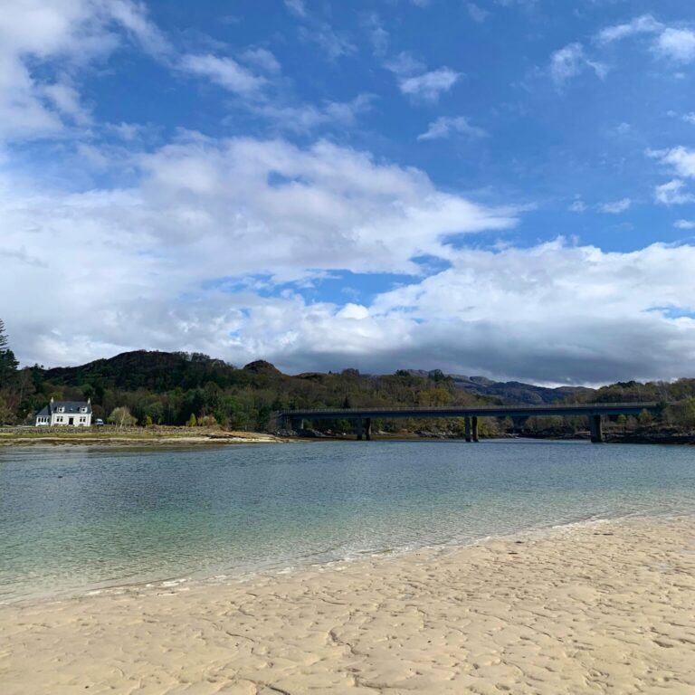 Camusdarach Beach with a white cottage and bridge