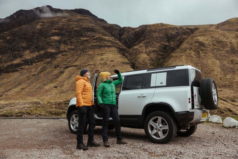 Couple standing next to a Land Rover in Scotland