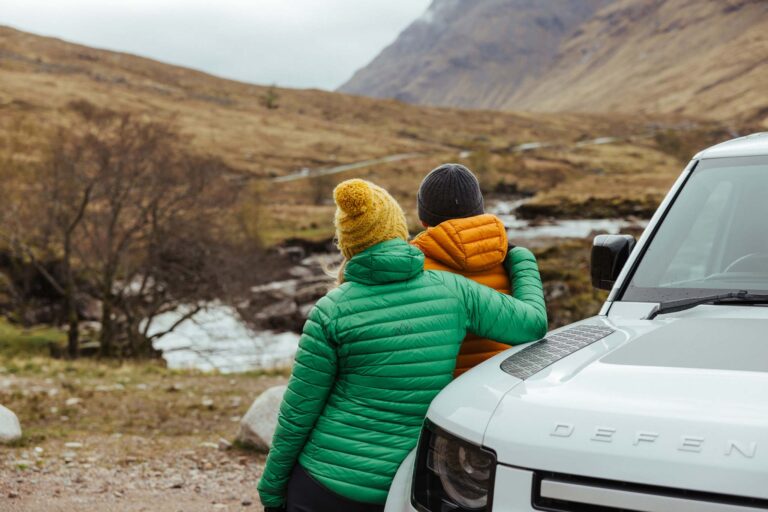 Couple leaning on the bonnet of a Land Rover in Scotland