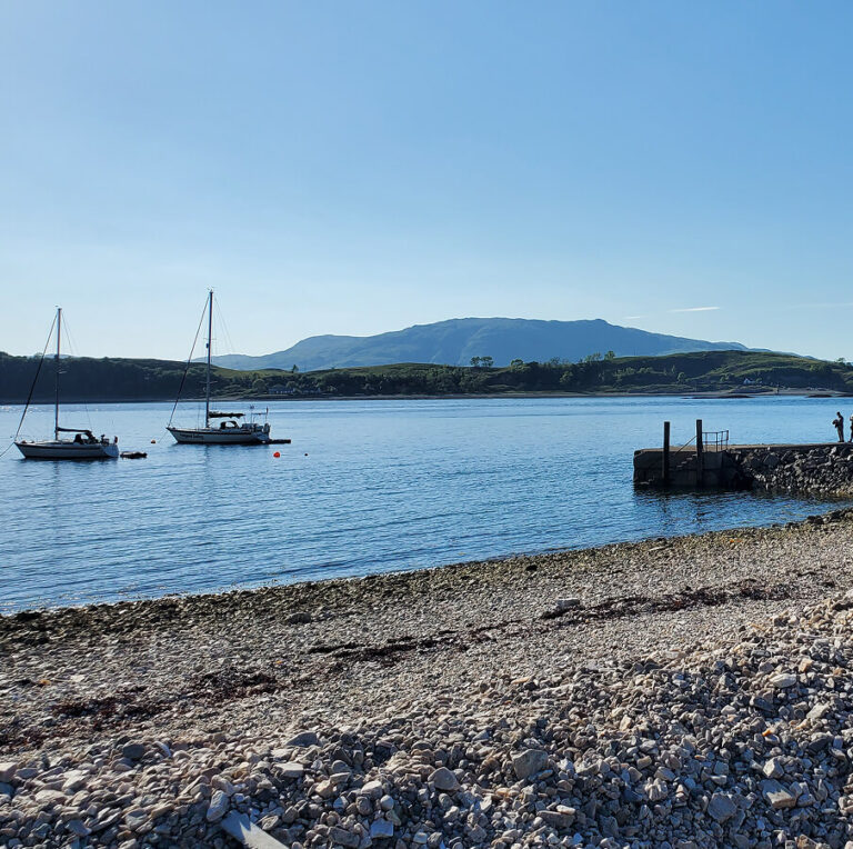 Sailing boats moored off a quiet Scottish beach